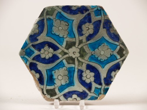 Tegel, zeskantig, met decor van geometrisch ornament met bloemrozetten